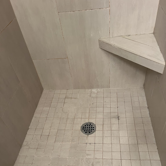 Dark, discolored shower grout before cleaning